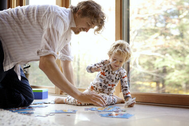 Vater und Sohn ordnen ein Puzzle zu Hause - CAVF10868