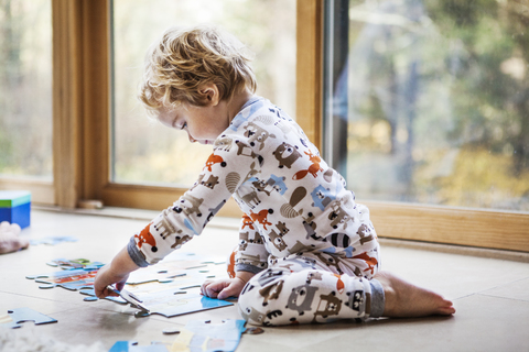 Kleiner Junge spielt Puzzle zu Hause, lizenzfreies Stockfoto