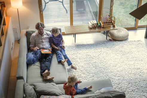 Blick von oben auf eine Familie, die sich auf dem Sofa zu Hause entspannt - CAVF10890