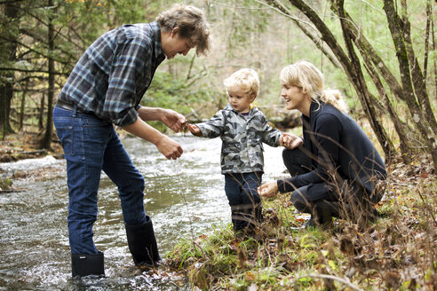 Glückliche Familie beim Anblick eines Skorpions am Fluss - CAVF10913