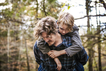 Vater nimmt seinen Sohn im Wald huckepack - CAVF10924