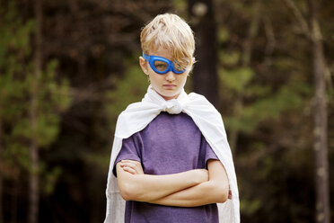 Portrait of boy wearing cape standing with arms crossed - CAVF10928