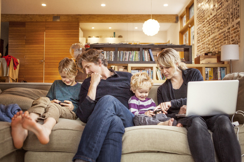 Glückliche Familie auf dem Sofa zu Hause, lizenzfreies Stockfoto