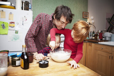 Vater und Söhne beim Kochen in der Küche zu Hause - CAVF10937