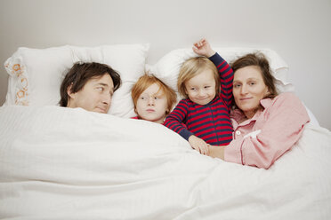 Glückliche Familie auf dem Bett liegend zu Hause - CAVF10950