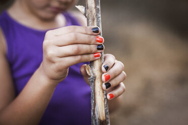 Girl holding wood stick in forest - CAVF11040