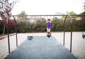 Girl playing on swing at park - CAVF11043