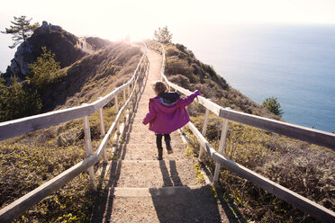 Rear view of girl descending steps on mountain - CAVF11102