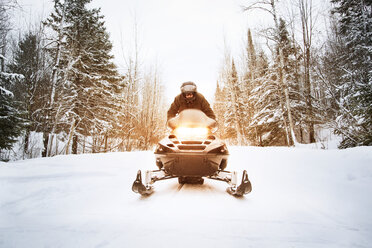 Mann fährt Schneemobil auf Wanderweg mitten im Wald - CAVF11214