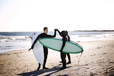 Surfer, die am Strand stehend ihre Fäuste ballen - CAVF11287