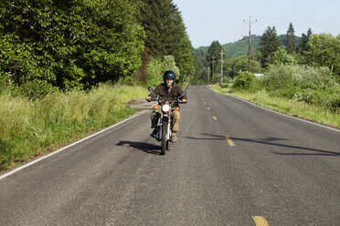 Man riding motorcycle on road - CAVF11391