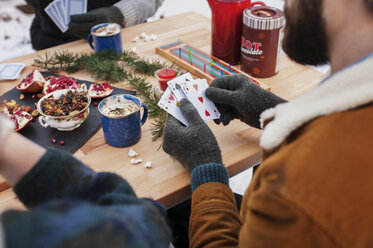 Hohe Winkel Ansicht von Freunden spielen Karten auf dem Tisch im Hinterhof - CAVF11458