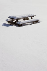 Mit Schnee bedeckter Picknicktisch auf einem Feld - CAVF11487