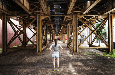 Rear view of woman standing below bridge - CAVF11488