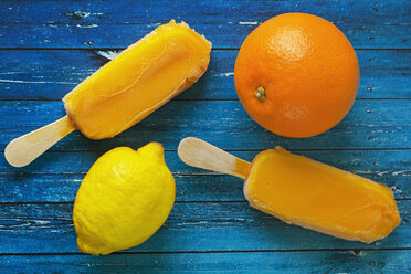 Overhead view of orange and lemon by popsicles on table - CAVF11547