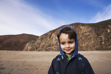 Boy smiling while standing on shore at beach - CAVF11691