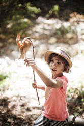 Girl touching leaf on twig on field - CAVF11726