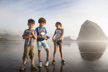 Children standing on shore at beach against sky - CAVF11769