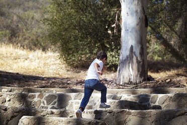 Boy running on stone staircase - CAVF11830