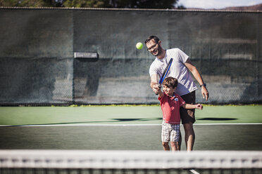 Vater und Sohn spielen Tennis auf dem Platz - CAVF11862