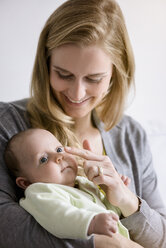 Lächelnde Mutter mit ihrem kleinen Jungen, der die Nase streichelt - BMOF00043