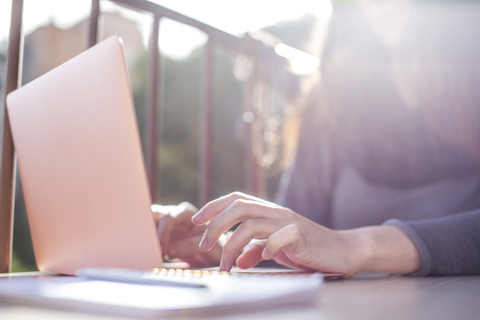 Hand einer Frau auf der Tastatur eines Laptops, lizenzfreies Stockfoto