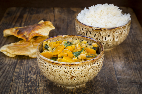 Currygericht mit Blumenkohl, Butternusskürbis, Spinat und Koriander, Papadam und Reis, lizenzfreies Stockfoto