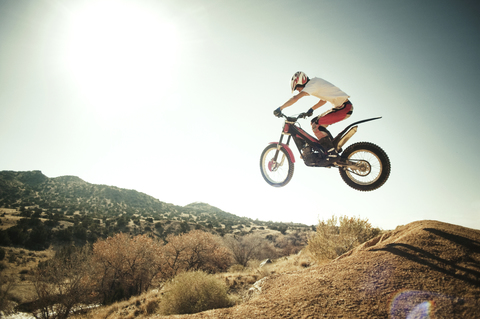 Side view of man performing stunt with motorcycle against clear sky stock photo