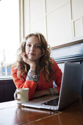 Portrait of woman with hand on chin sitting in cafe - CAVF12008