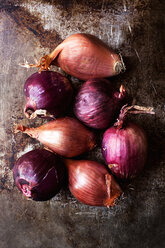 Overhead view of various onions on old kitchen counter - CAVF12110