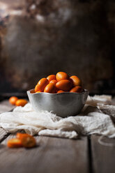 Nahaufnahme von Kumquats in einer Schale auf dem Tisch - CAVF12117