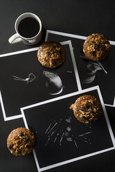 Hochformatige Ansicht von Muffins mit Kaffee und Fotos auf dem Tisch - CAVF12244