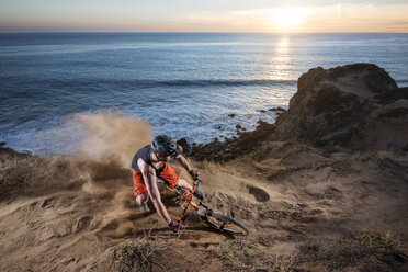 Athlete with bicycle at beach against sky during sunset - CAVF12307