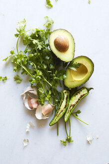 Overhead view of avocado and vegetables over white background - CAVF12345