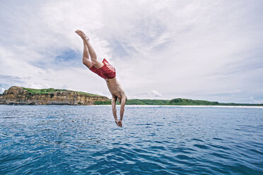 Hemdloser Mann taucht ins Meer gegen bewölkten Himmel - CAVF12416