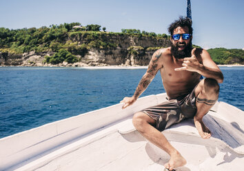 Portrait of shirtless man in sunglasses sitting on sailboat during sunny day - CAVF12418