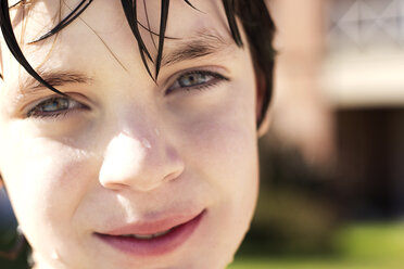 Porträt eines lächelnden nassen Jungen im Freien - CAVF12432