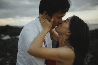 Nahaufnahme eines sich küssenden Paares am Strand gegen den Himmel bei Sonnenuntergang - CAVF12440