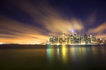 Scenic view of illuminated city and river against sky at dusk - CAVF12446