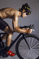 Seitenansicht eines Mannes mit Fahrradhelm vor lila Hintergrund - CAVF12452