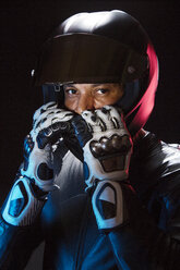 Porträt eines Motorradfahrers mit Helm vor klarem Himmel - CAVF12462
