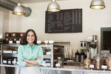 Portrait of happy owner standing in coffee shop - CAVF12473