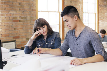 Businessman explaining plan to colleague while working in office - CAVF12531