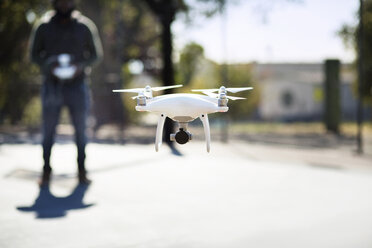 Close-up of drone operated by man in basketball court - CAVF12564