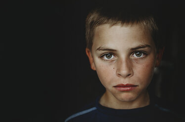 Porträt eines Jungen in einem dunklen Raum - CAVF12590