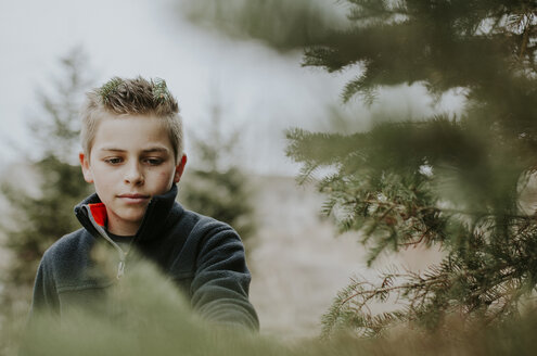 Junge schaut inmitten von Bäumen im Wald weg - CAVF12619