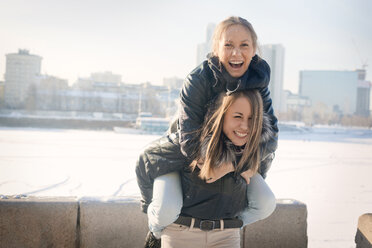 Portrait of cheerful woman giving piggyback to friend - CAVF12774