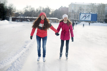 Happy friends ice-skating in park - CAVF12777