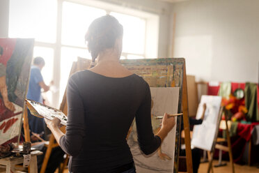 Rückansicht einer Frau beim Malen im Stehen im Kunstunterricht - CAVF12781