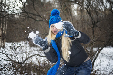 Frau spielt mit Schnee auf einem Feld - CAVF12851